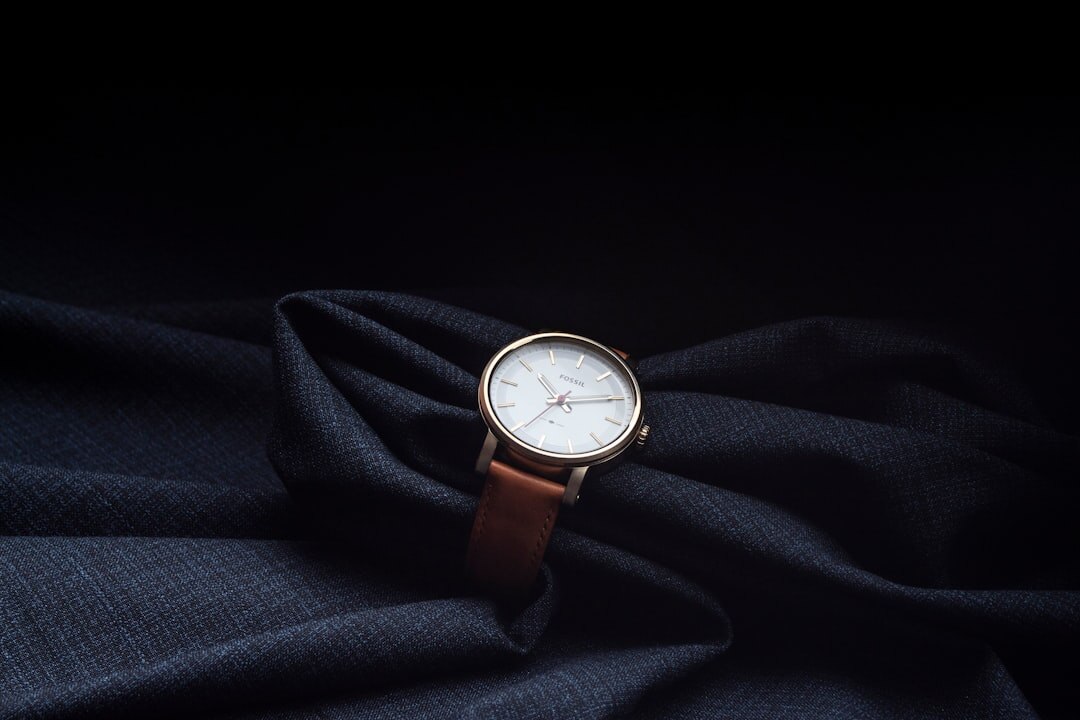Slim leather strap dress watch on a wooden surface
